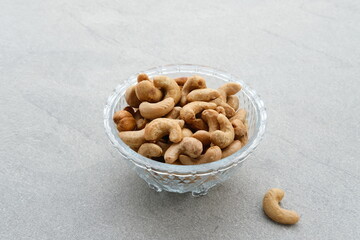 Cashew Nut, in Indonesia known as Kacang Mete. Served in a small bowl on grey background. 