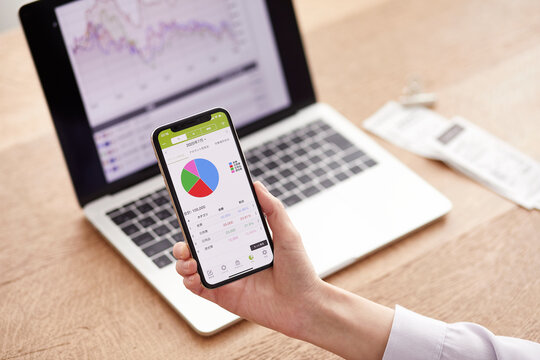 パソコンとスマートフォンでお金の管理をする女性