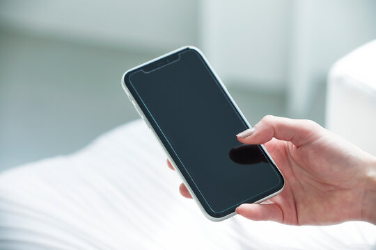 スマートフォンを持つ女性の手元