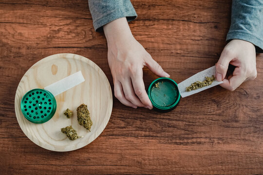 Top view woman hands rolling CBD cannabis weed joint - Alternative treatment for anxiety