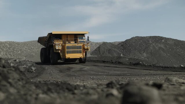 Empty dump truck moves quickly to load coal. Movement towards the camera.