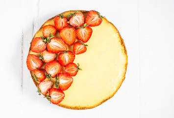 Sweet breakfast, delicious cheesecake with fresh strawberries, homemade recipe on white wooden table.