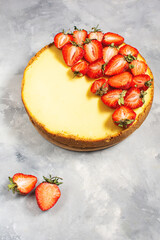 Sweet breakfast, delicious cheesecake with fresh strawberries, homemade recipe on a concrete table.