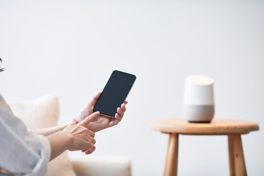 スマートスピーカーとスマートフォンと女性の手