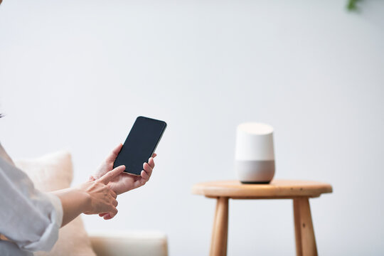 スマートスピーカーとスマートフォンと女性の手
