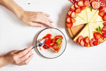 Piece of cheesecake with fresh strawberries jam and mint. Tasty homemade cheesecake on white background. Top view