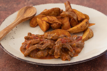 goulash de boeuf et pommes de terre wedge en gros plan dans une assiette