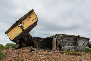 The wreck of an old wooden fishing boat on the shingle beach at Dungeness, Kent, UK