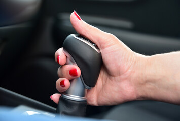 Female hand on automatic transmission lever, close up