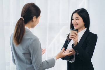 Two asian business woman work together to get the job done at the office