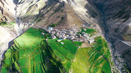 wide aerial landscape of lush green farmland in Mud Village during summer in Pin Valley of Himachal...