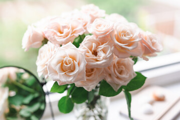 Bouquet of roses on the windowsill in the interior of the bedroom.