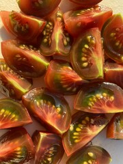 Sliced quarters of a dark cherry tomato