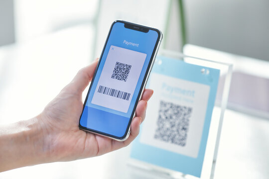 スマートフォンを持ちキャッシュレス決済をする女性の手元