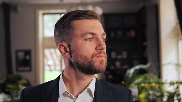 Charismatic businessman standing in restaurant hall thinking. Confident man resting lounge hotel bar. Elegant employee pondering business project in modern cafe. Scowling male face expression closeup.
