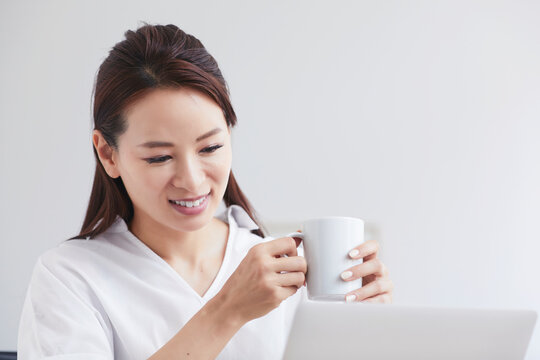 ノートパソコンを使い部屋で仕事をする女性