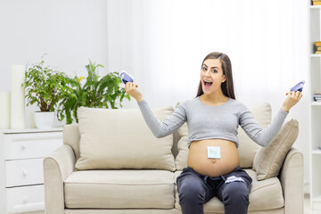 Photo of pregnant woman holding a paper with sex of the child.