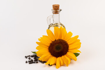 Sunflower oil in glass jug, seeds and flower isolated on white background