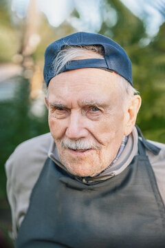 Portrait Of A Cheerful 88-year-old Man In A Baseball Cap. Happy Active Old Age