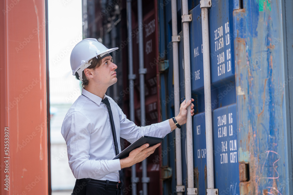Poster businessman are overseeing the transportation of cargo with containers inside the warehouse,containe