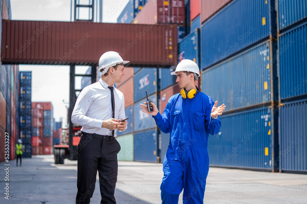 Poster Manager and Technicians planning the transportation of goods for import Or export in the container yard,Checking on shipping containers.