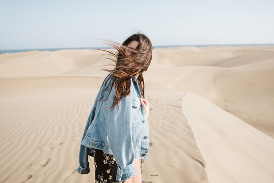 Woman standing on sand land and blue sky