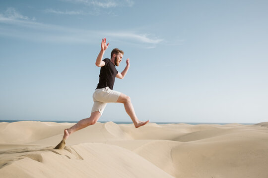 Man jumping on sand land and blue sky