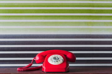 Red old fashioned telephone on table