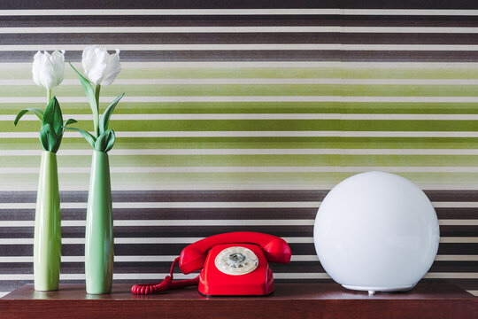 Old fashioned telephone with lamp and vases of tulips