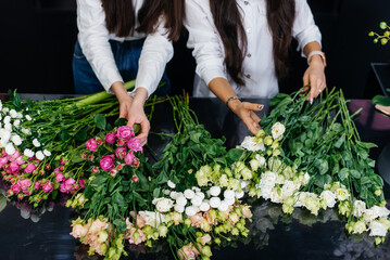Close-up of women's hands collecting and making beautiful festive bouquets in a cozy flower shop. Floristry and bouquet making in a flower shop. Small business.