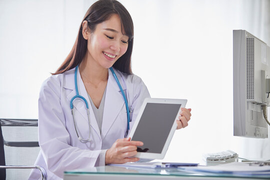 タブレットPCを持つ白衣を着た女性