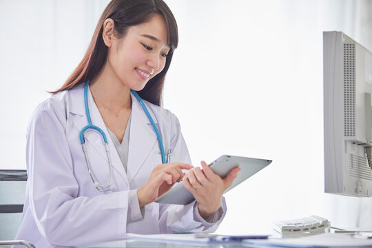 タブレットPCを持つ白衣を着た女性