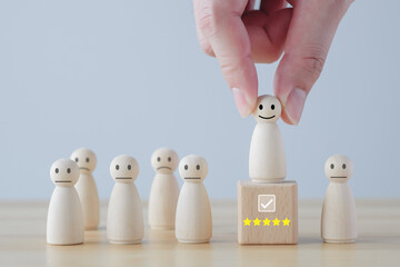 Hand pick happy face wooden figure. Customer service rating experience and feedback emotion and...