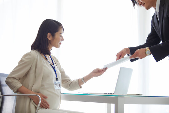 仕事をする妊婦女性と男性