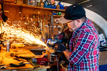 Male cutting piece of metal in modern workshop