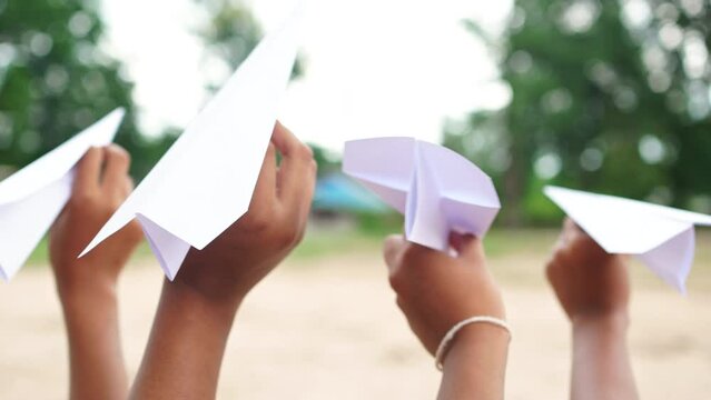 Girl playing fun with airplanes made from paper fun, creative, toys made from natural materials.