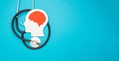 A brain shape made from paper and a stethoscope on a light blue background