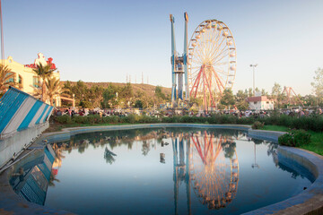 cityscape for an amusement park and children games with nice ferris wheel , mostaland park in...