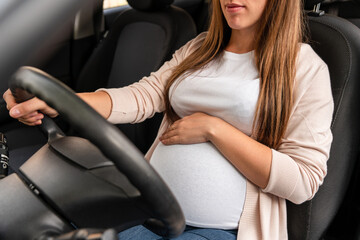Obraz na płótnie Canvas Woman driving car. Beautiful smiling pregnant woman driving car. Safety pregnancy young mother drive concept.
