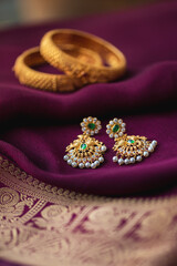 Gold earring on a purple traditional indian saree