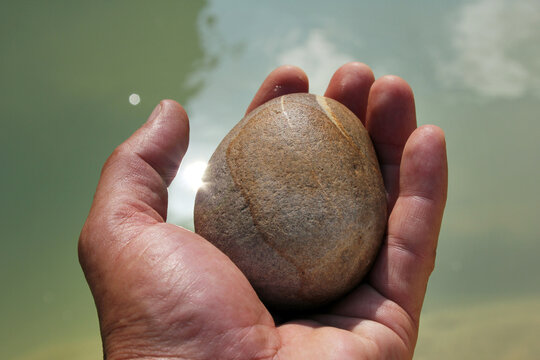 A hand holding a stone. Man and nature.