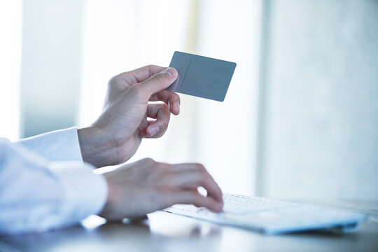カードとキーボードと男性の手