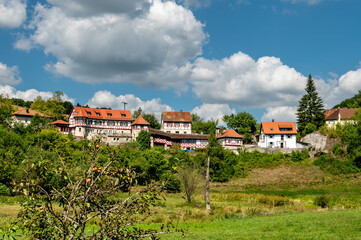 Historische Häuser auf Anhöhe in Naturlandschaft im Sommer