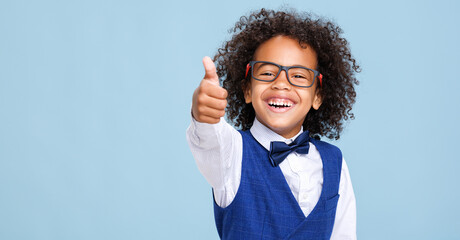 Happy ethnic schoolboy in formal suit and glasses approving school education