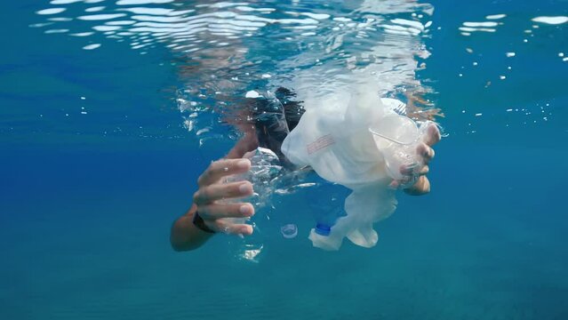Boy collects plastic in polluted ocean