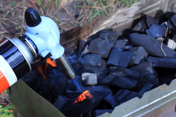 gas burner kindles coals, kindle a fire with a burner, a flame from a burner, ready-made coals in...