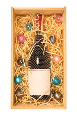 Bottle of champagne with copy space label in wooden box with baubles isolated on white background, Christmas gift box concept.