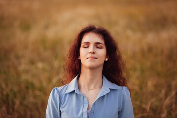 Woman in the field with flowers on sunset background