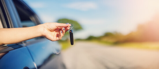 Woman's hand holding key from her new car