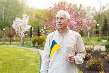 Senior man with Ukrainian flag. Elderly man in national clothes with the flag of Ukraine. Elderly man in national clothes with the flag of Ukraine. The independence day of Ukraine